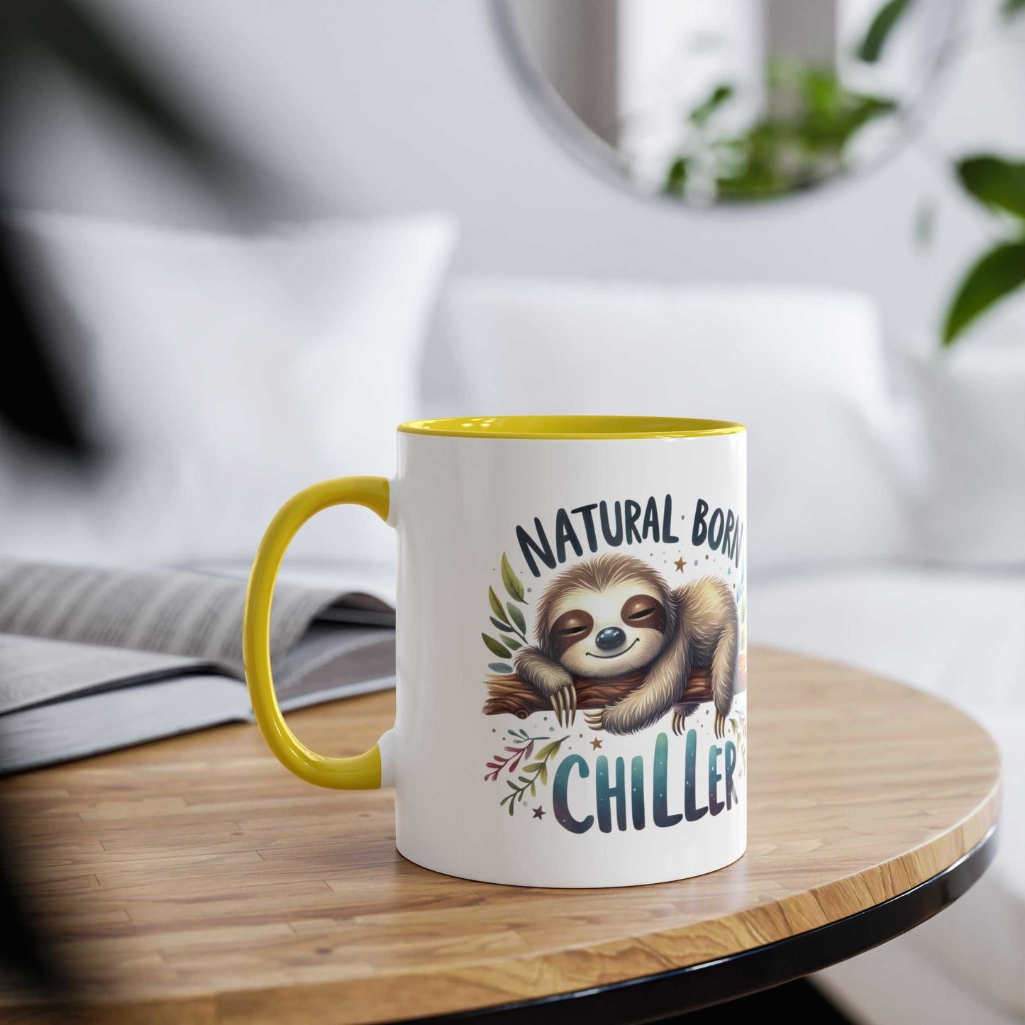 Cute sloth coffee mug with text "Natural Born Chiller" on a table.