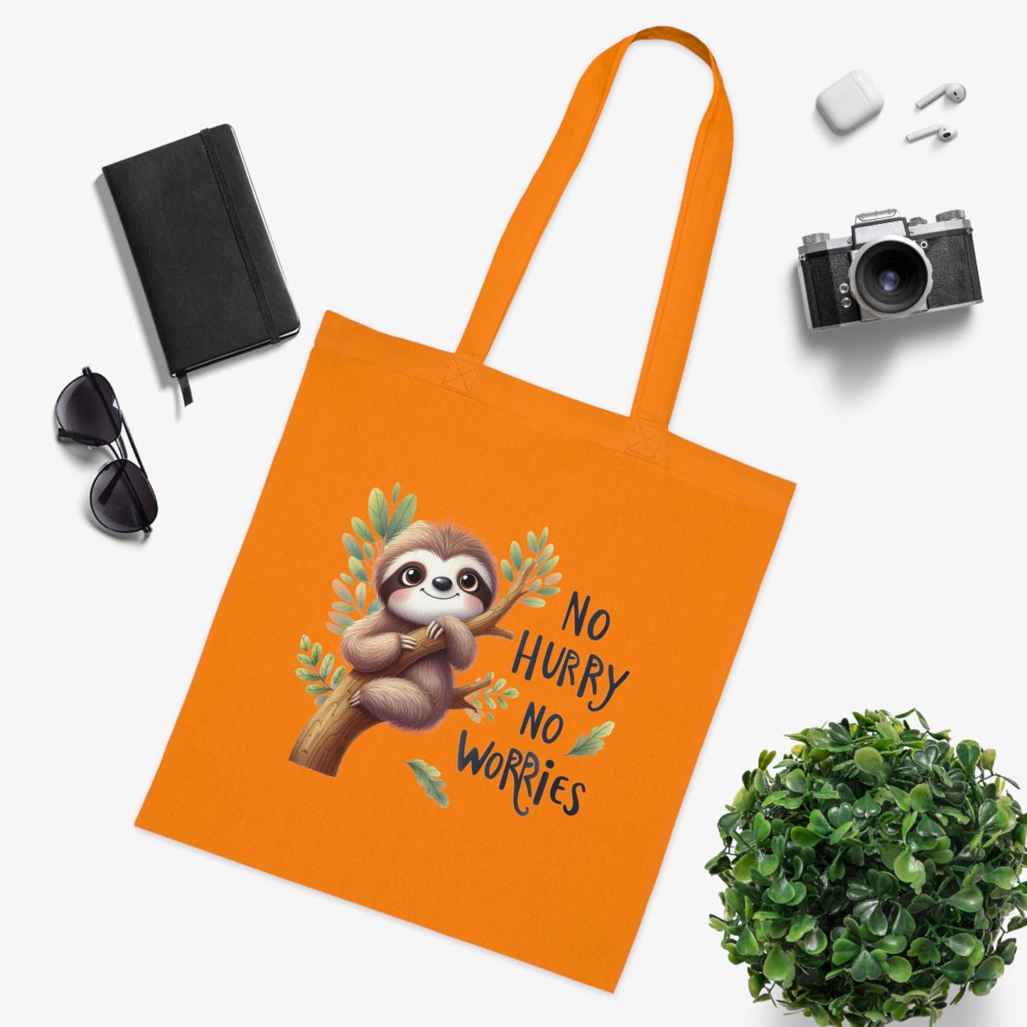 Orange cotton tote bag with cute sloth design and "No Hurry No Worries" text.