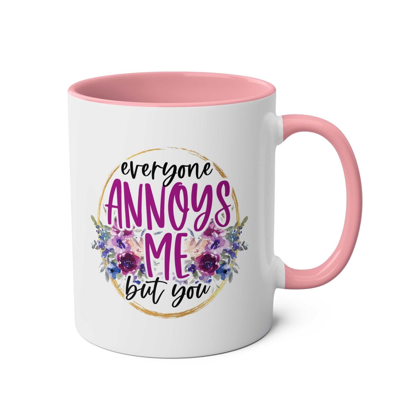 Everyone Annoys Me But You coffee mug with floral design and pink handle.