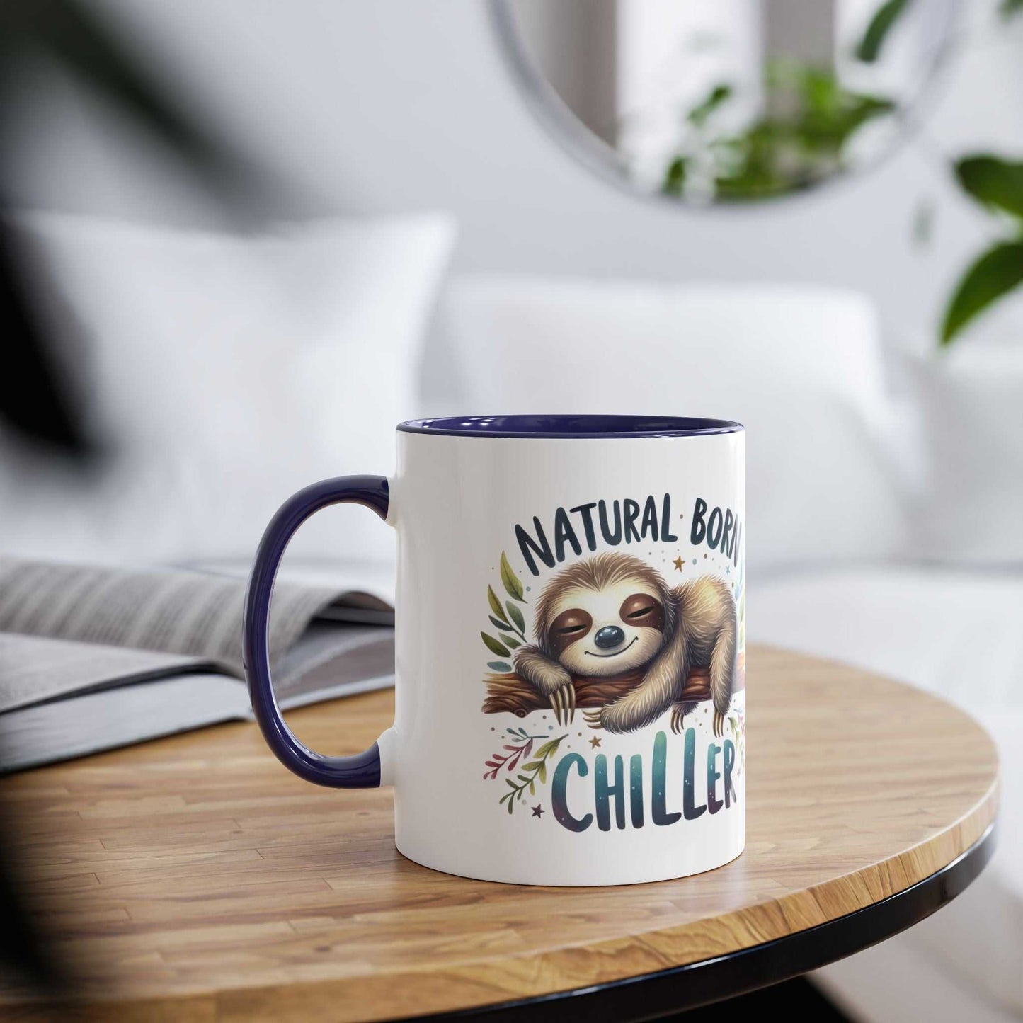Cute sloth coffee mug with "Natural Born Chiller" design on wooden table.