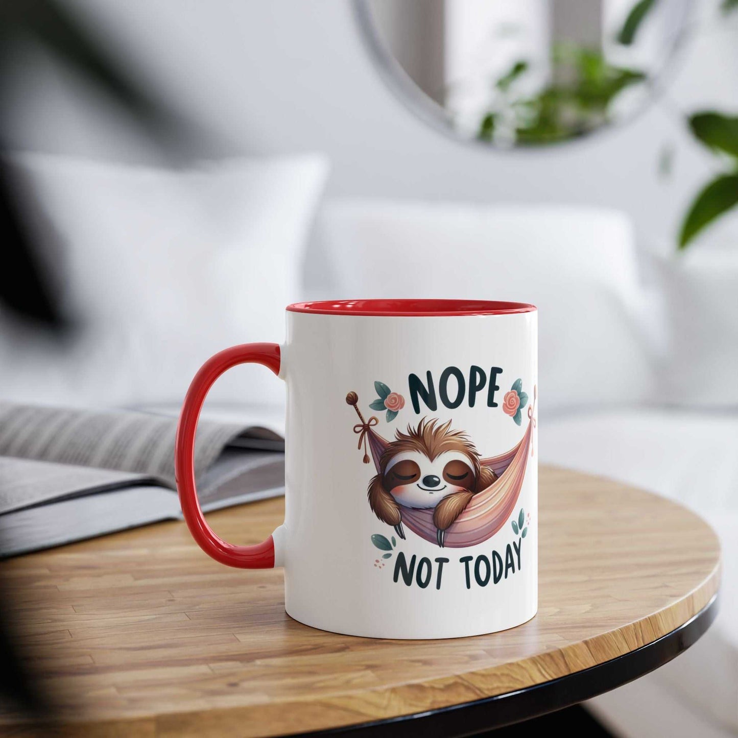 Cute sloth coffee mug with "Nope Not Today" design on table, red handle.