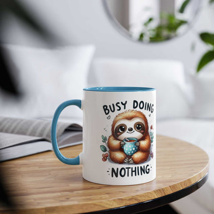 Cute sloth coffee mug with cheerful design and blue handle, perfect for animal lovers.