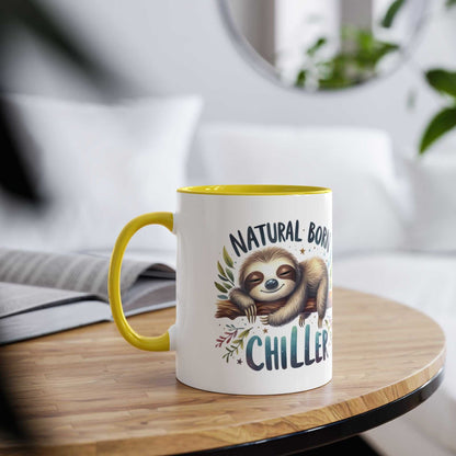 Cute sloth coffee mug with text "Natural Born Chiller" on a table.