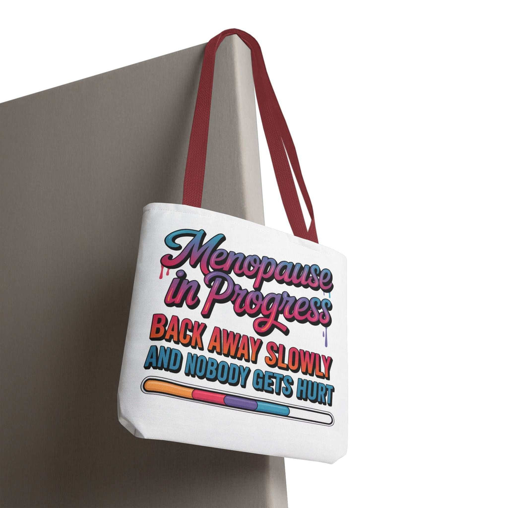 Menopause in Progress tote bag with cheeky design, durable spun polyester, multiple sizes and handle colors, reusable and lightweight