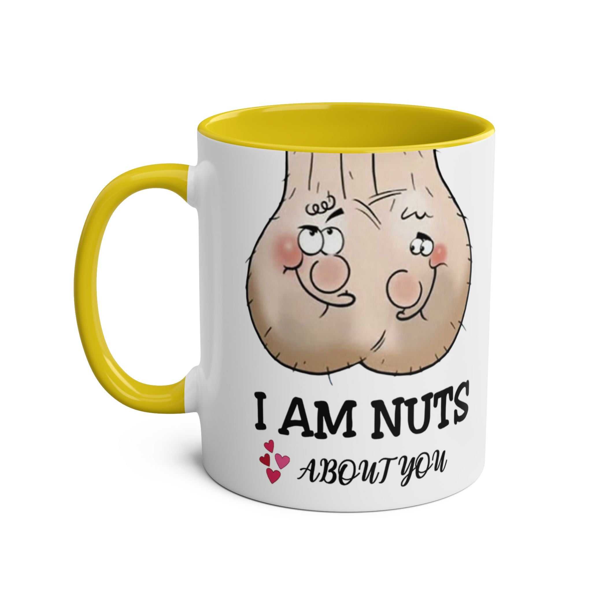 White ceramic "Nuts About You" mug with yellow handle and interior, featuring a cheeky nut illustration and playful text.