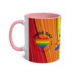 LGBTQ+ Pride mug with vibrant rainbow design and pink handle.