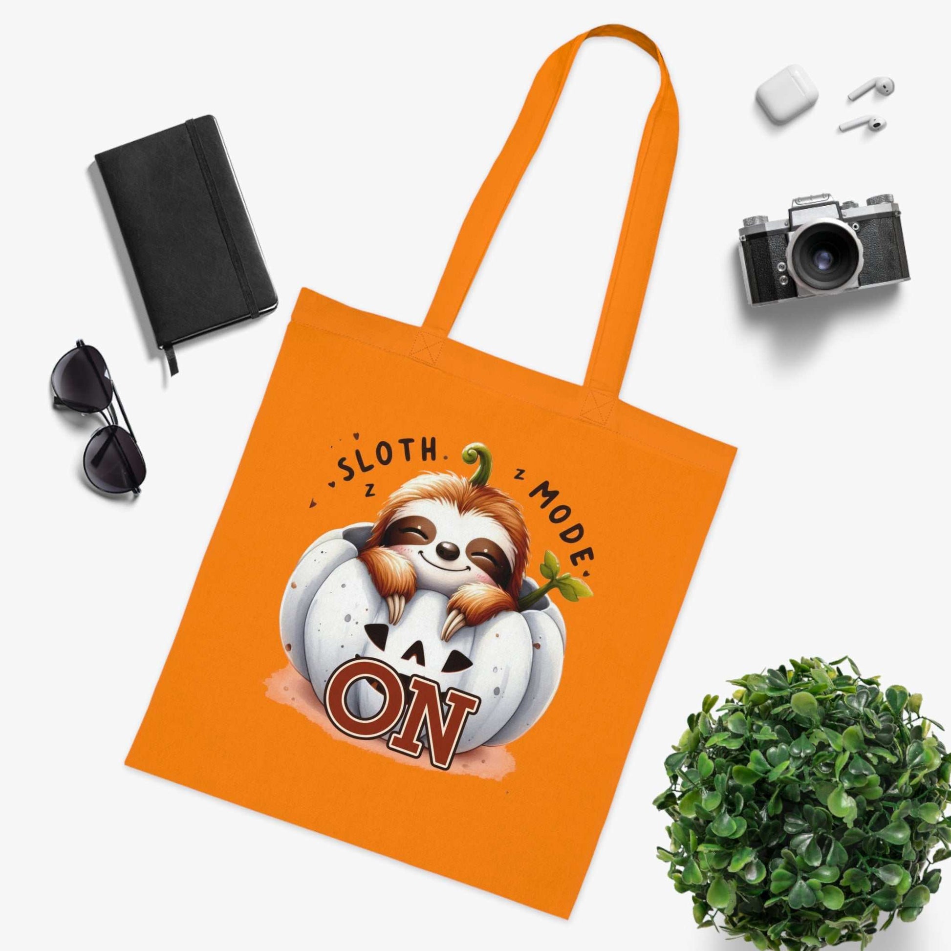 Cute sloth design cotton tote bag in vibrant orange, ideal for everyday use and gifting.