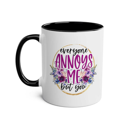 Everyone Annoys Me But You coffee mug with floral design, black handle, and glossy finish.
