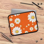 Orange laptop sleeve with white daisy pattern, neoprene protective cover for laptops, lightweight and waterproof with dual zipper closure