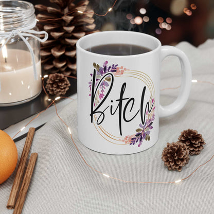 White 11oz ceramic Bitch Ceramic Mug with floral and gold circle design, glossy finish, shown with coffee and cozy autumn decor.