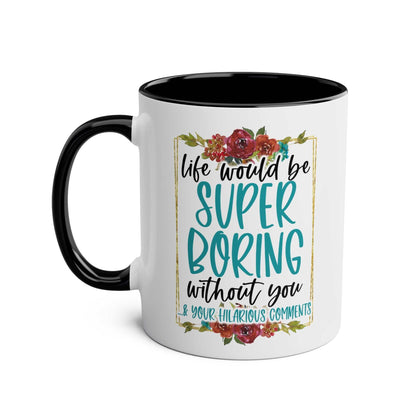 White ceramic mug with black handle and text "Life Would Be Super Boring Without You" in playful font, featuring floral accents.