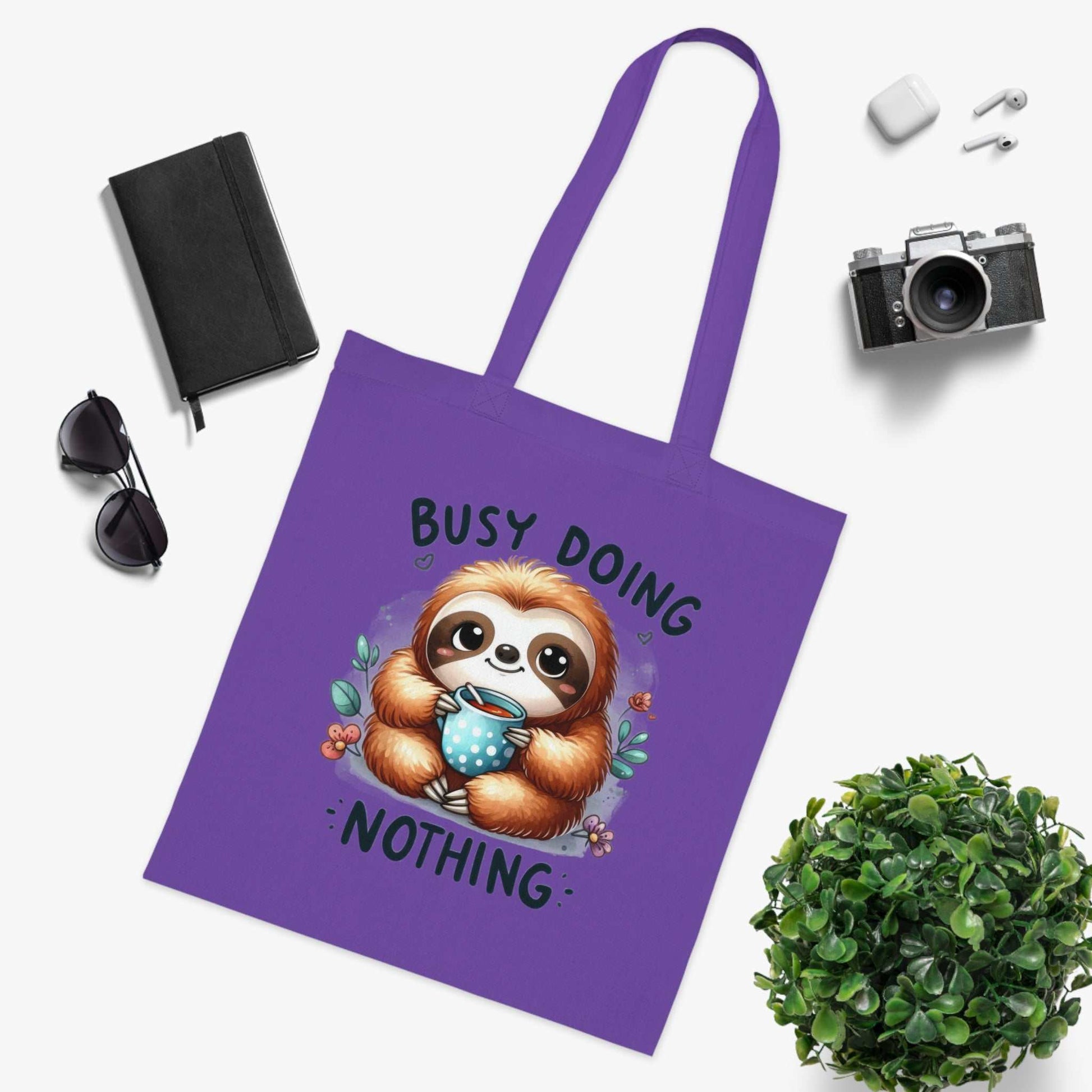 Cute sloth tote bag with vibrant design and "Busy Doing Nothing" text, perfect for everyday essentials.