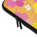 Close-up of retro floral laptop sleeve with dual zipper and colorful flower pattern on orange background