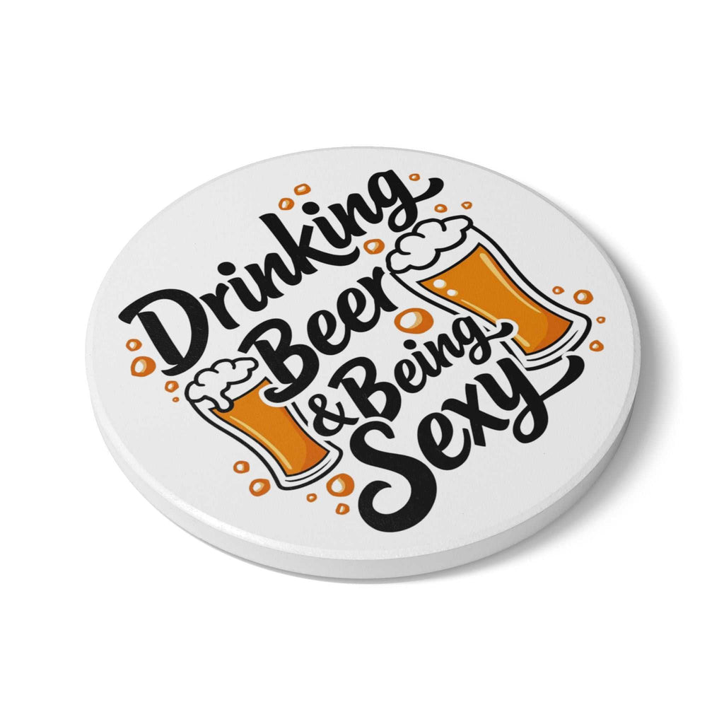 Round ceramic coaster with Drinking Beer Being Sexy text and beer glass illustrations, cork backing, for hot and cold drinks.