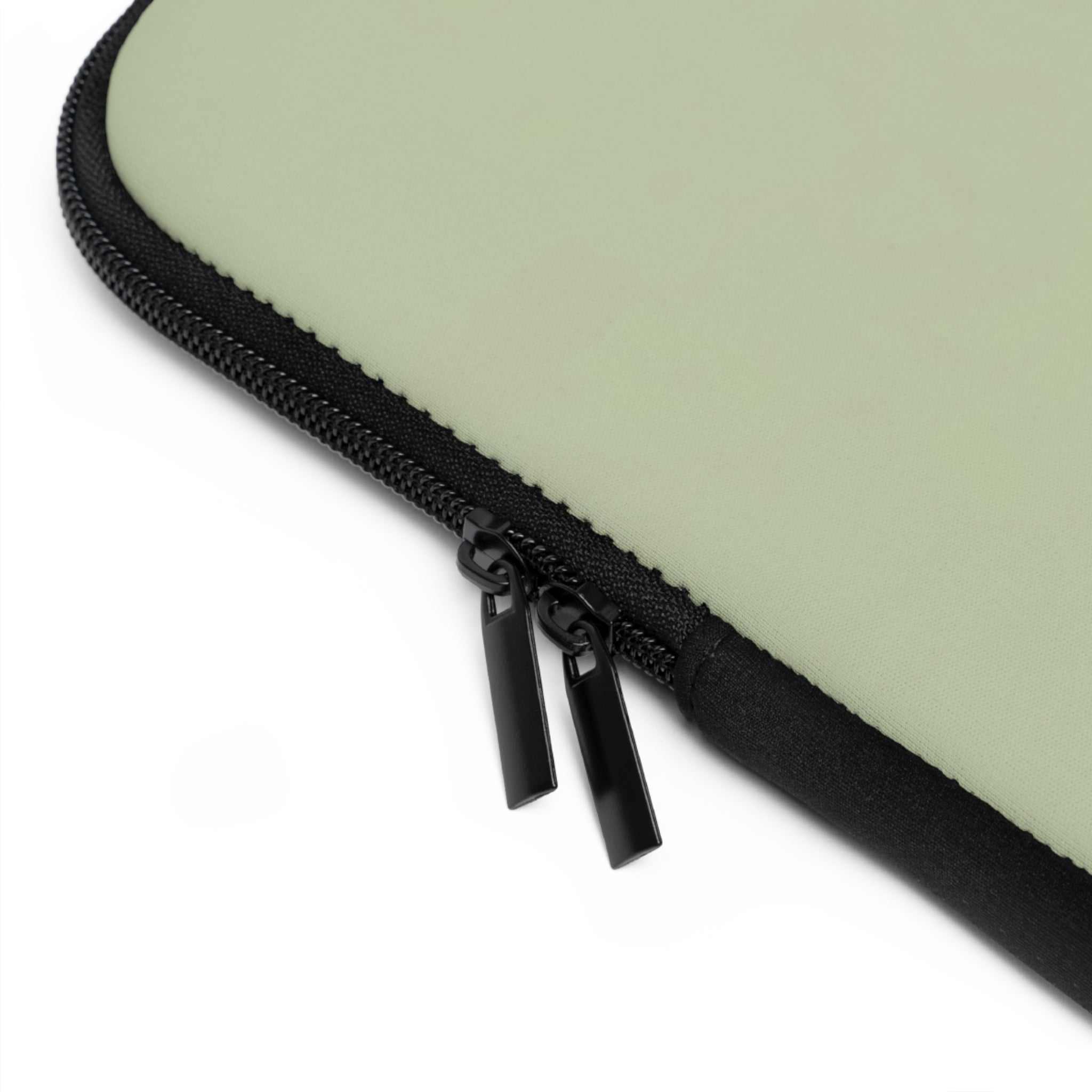 Close-up of sage green laptop sleeve with black dual zipper and smooth neoprene material