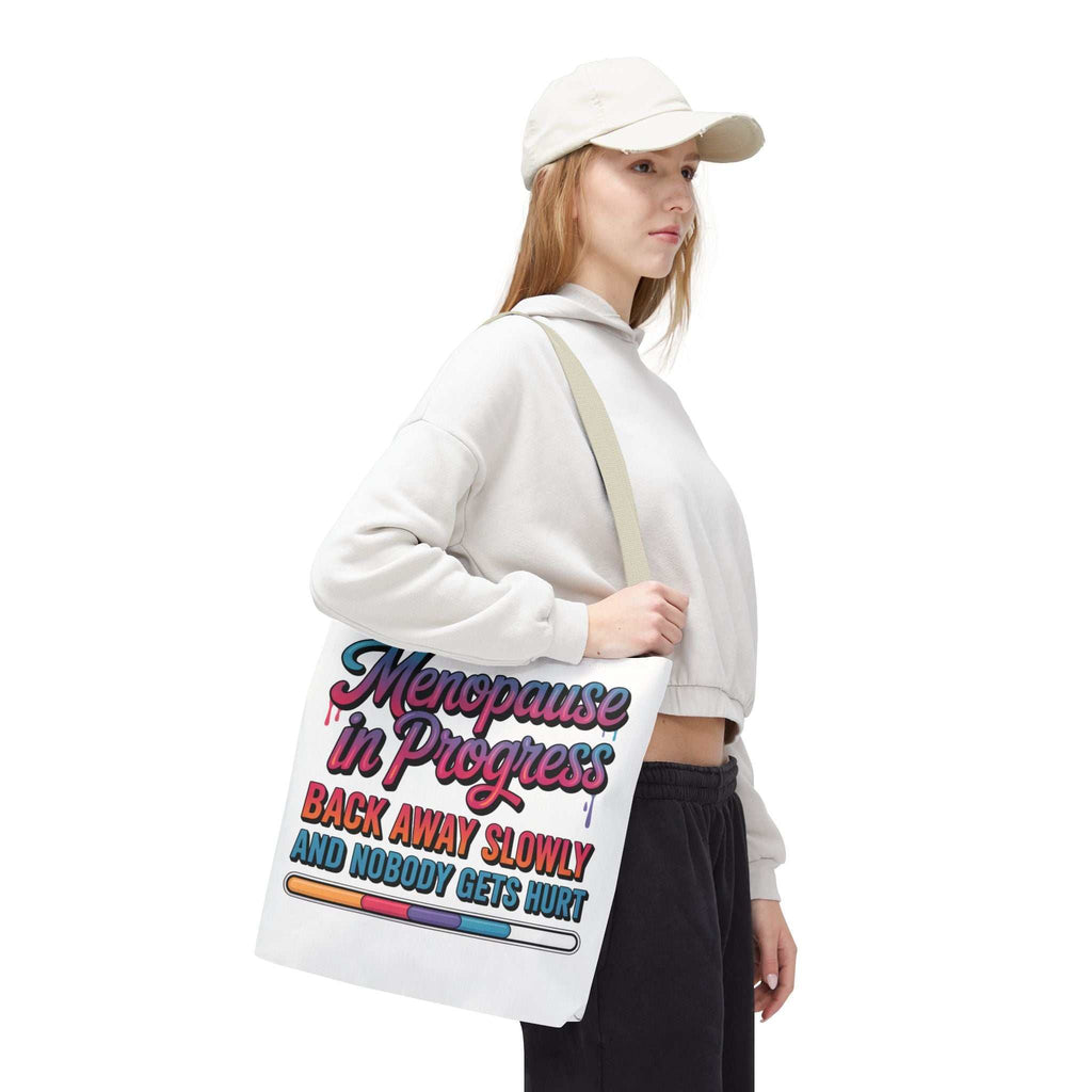 Menopause in Progress tote bag with cheeky design, durable spun polyester, multiple sizes and handle colors, reusable and lightweight