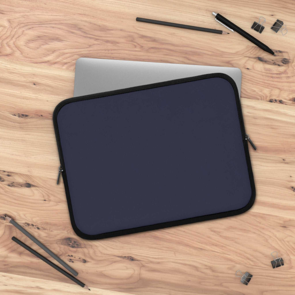 Deep blue neoprene laptop sleeve with soft foam lining, dual zipper, lightweight and waterproof design on wooden desk