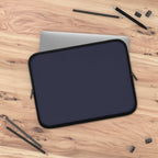 Deep blue neoprene laptop sleeve with soft foam lining, dual zipper, lightweight and waterproof design on wooden desk