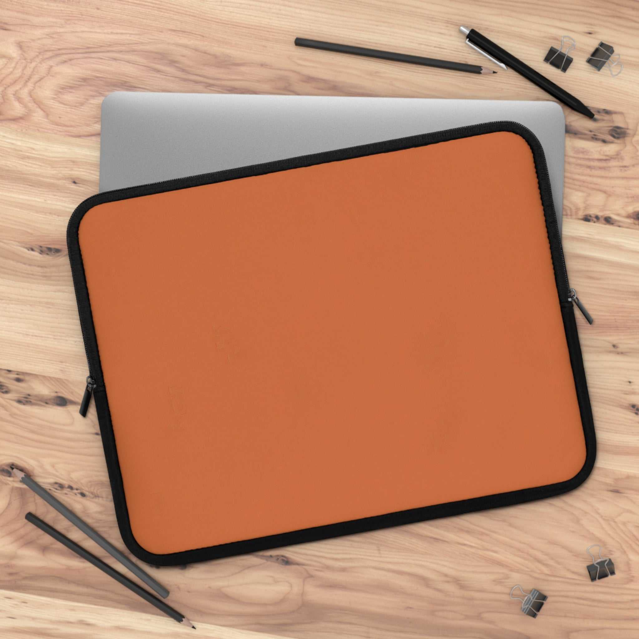 Bold orange neoprene laptop sleeve with black trim, dual zipper, and soft foam lining for protection.