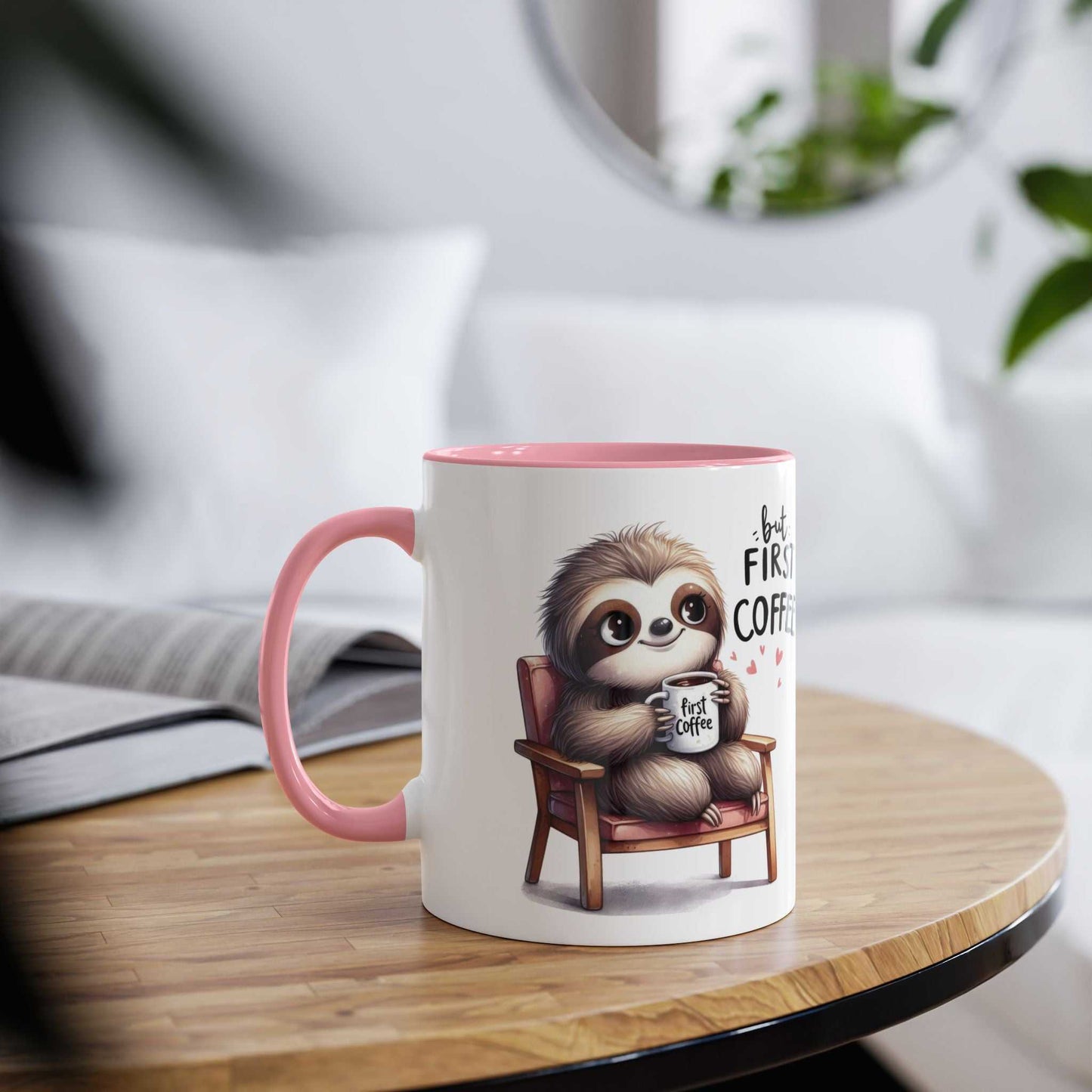 Cute sloth coffee mug with ceramic design and pink handle on wooden table.