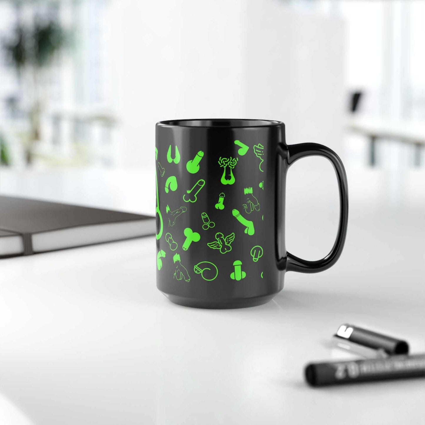 Black ceramic mug with playful green designs, glossy finish, available in 11oz and 15oz sizes.