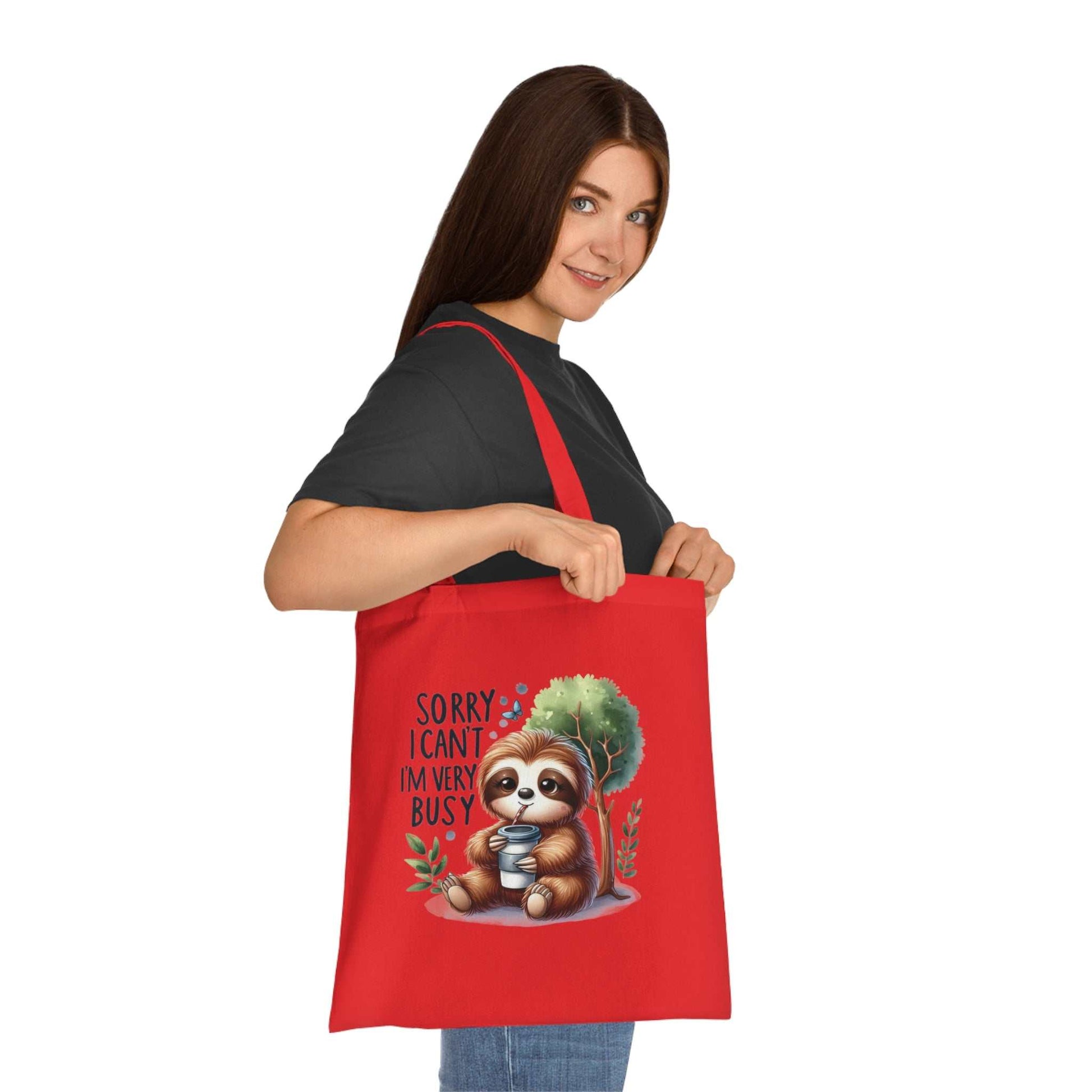 Cute sloth tote bag in vibrant colors, ideal for carrying essentials; 100% cotton with reinforced handles.