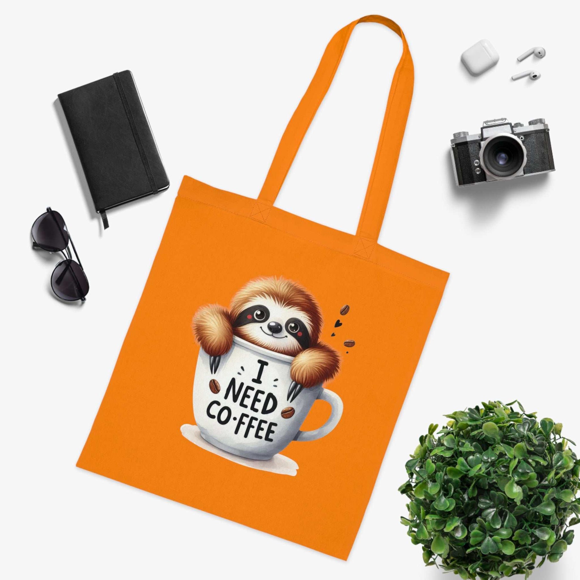 Orange cotton tote bag with a cute sloth design and coffee-themed print, ideal for sloth lovers.