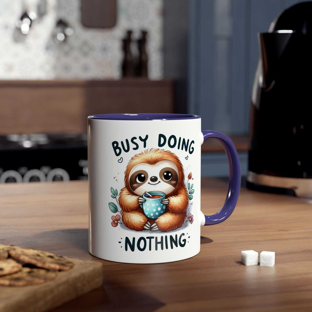 Cute sloth coffee mug with "Busy Doing Nothing" design on a wooden table in a cozy kitchen.
