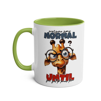 Playful giraffe design on the Everyones Normal Coffee Mug with green handle.