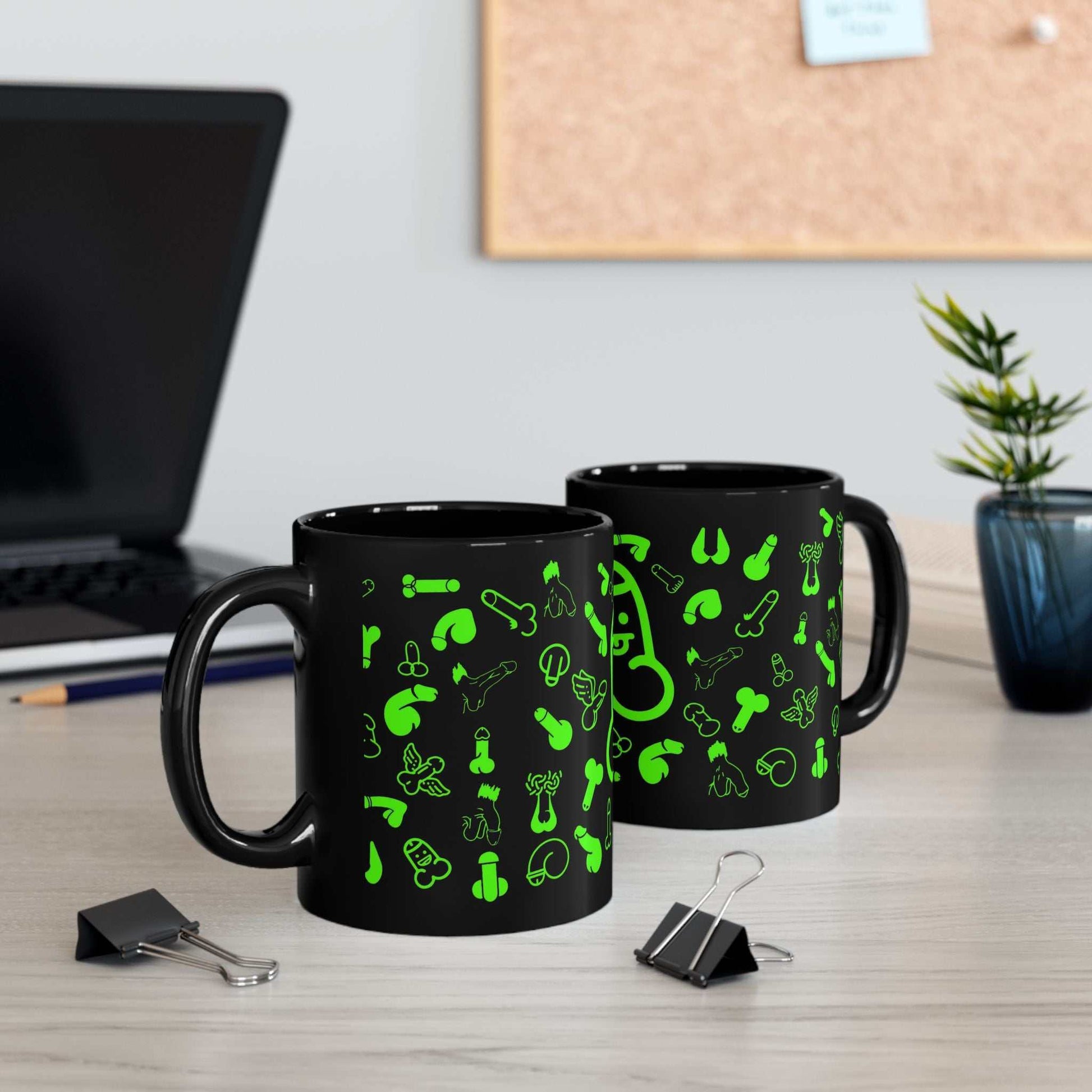 Black ceramic mug with playful green willie print, available in 11oz and 15oz sizes, featuring a glossy finish; perfect for adding fun to your collection.