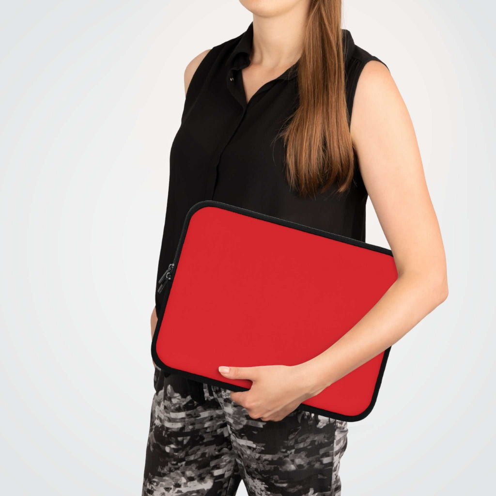 red neoprene laptop sleeve with soft foam lining and dual zipper being held by person