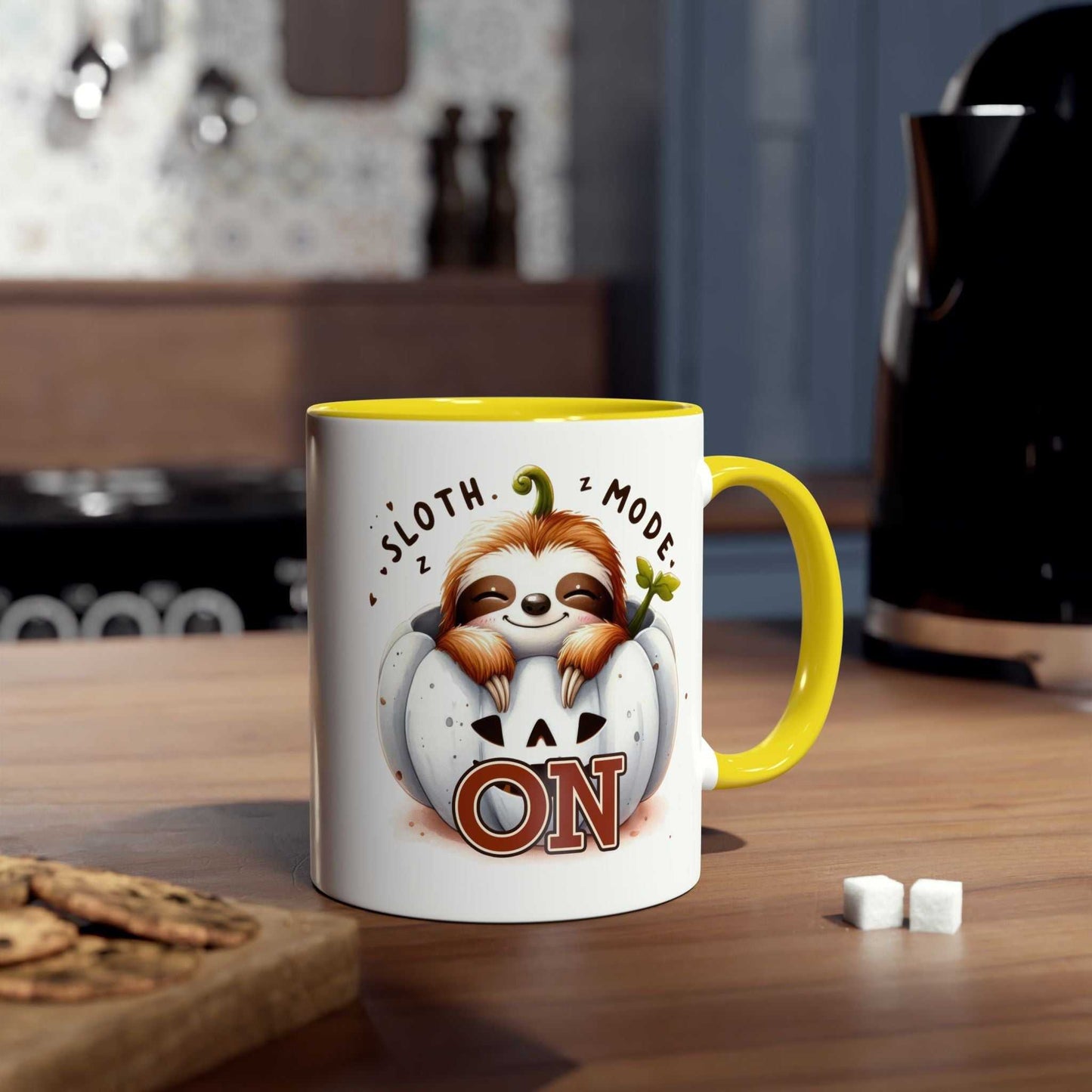 Cute sloth coffee mug with "Sloth Mode On" text and colorful handle in cozy kitchen setting.