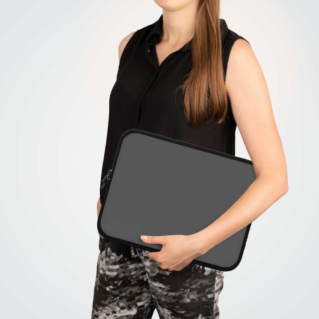 Woman holding gunmetal grey neoprene laptop sleeve with dual zipper and soft foam lining for protection
