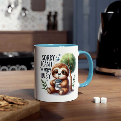 Cute sloth coffee mug with "Sorry I can't, I'm very busy" design, ideal for animal lovers, 11oz ceramic, microwave and dishwasher safe.