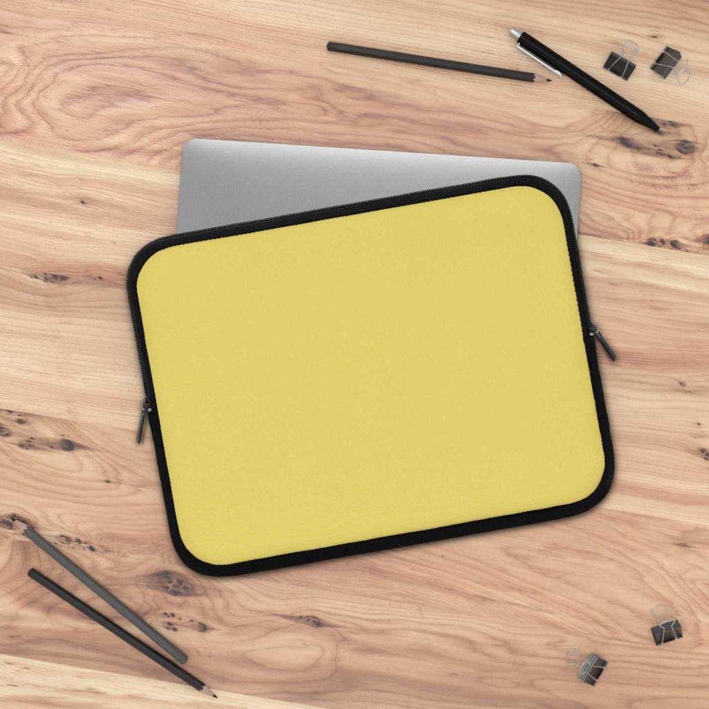 Lemon yellow neoprene laptop sleeve with soft foam lining and dual zipper on wooden desk