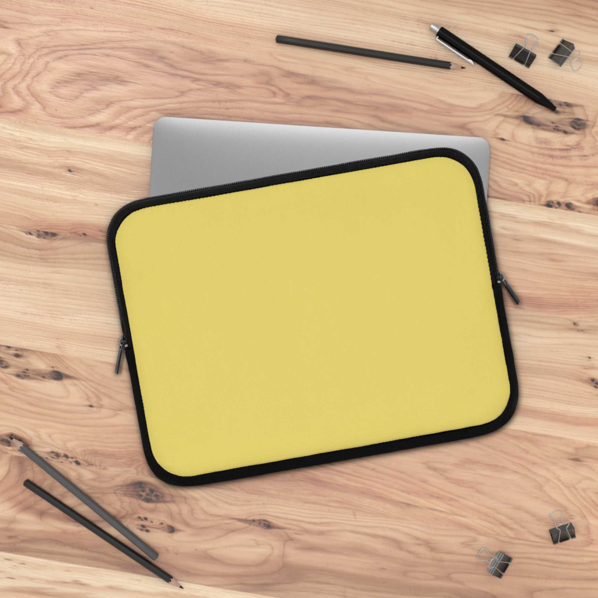 Lemon yellow neoprene laptop sleeve with soft foam lining and dual zipper on wooden desk
