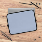 Misty Blue Laptop Sleeve made of durable neoprene with soft foam lining and dual zipper on wooden desk with laptop and stationery.