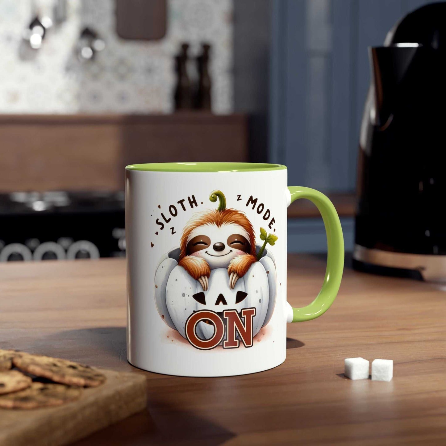 Cute sloth coffee mug with green interior, featuring sloth design and "Sloth Mode On" text, set in cozy kitchen.