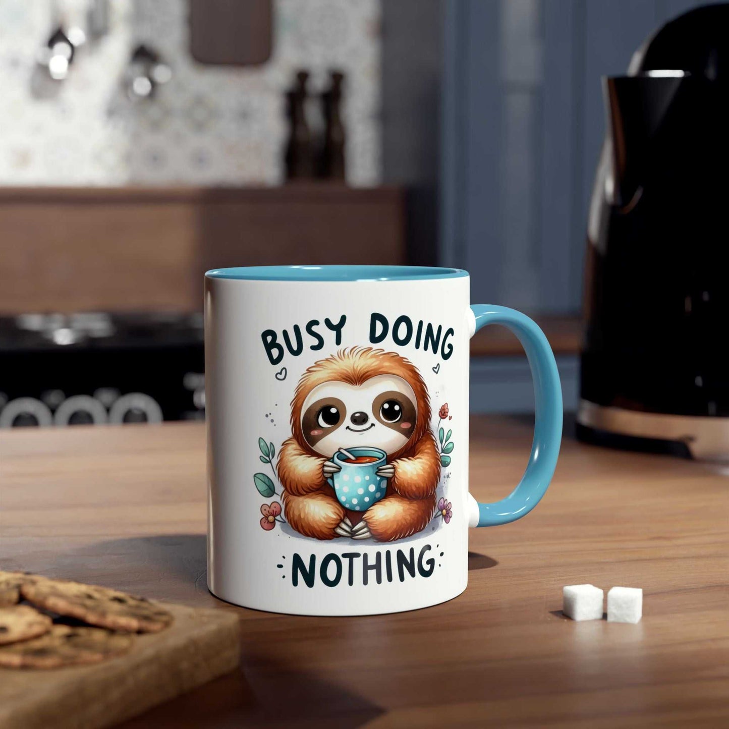 Cute sloth coffee mug with "Busy Doing Nothing" design on wooden table.