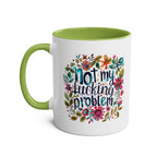 Colorful "Not My Problem" coffee mug with floral design and green interior.