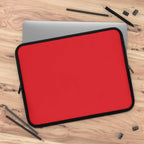 Red neoprene laptop sleeve with black trim, soft foam lining, dual zipper, lightweight, waterproof, fits most laptops.