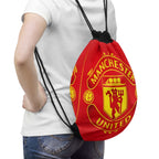 Manchester United drawstring bag in red and black with club crest, lightweight polyester, secure closure, and spacious interior for gym or travel