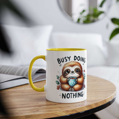 Cute sloth coffee mug with "busy doing nothing" text, yellow handle, 11oz ceramic, cheerful design.