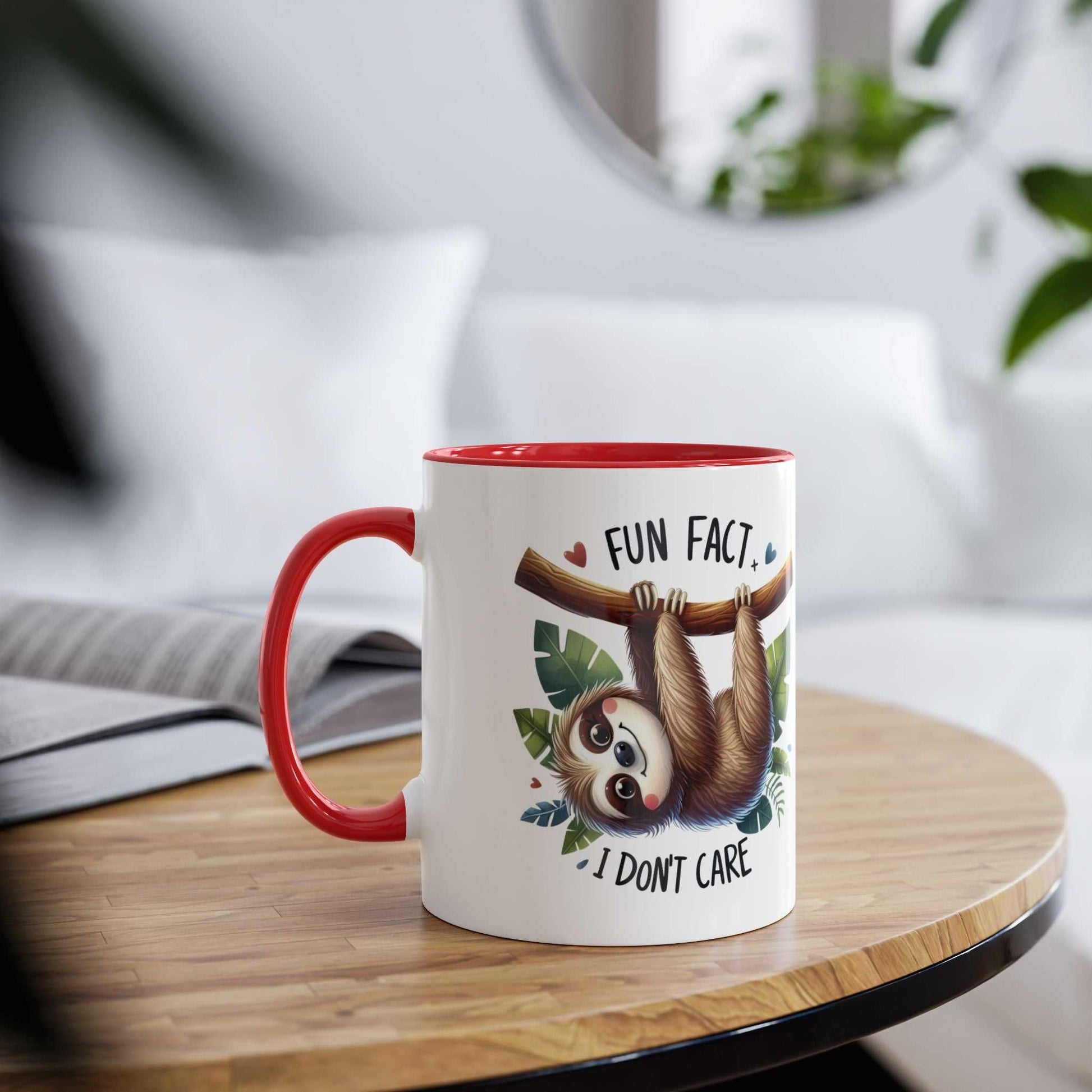 Cute sloth coffee mug with a whimsical design and red handle, resting on a table.