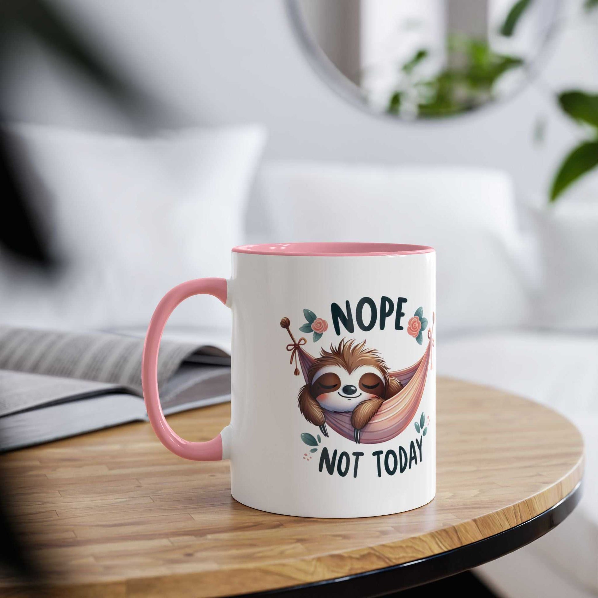 Cute sloth coffee mug with playful design on wooden table, pink interior and handle.