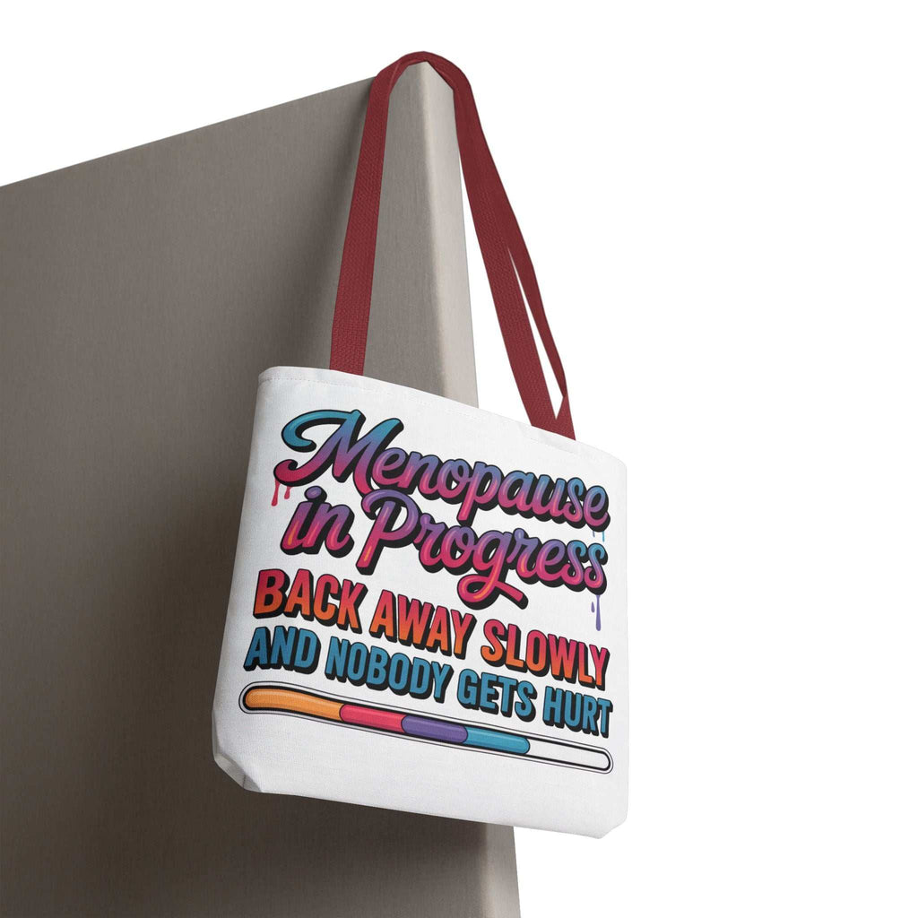 Menopause in Progress tote bag with cheeky design, durable spun polyester, multiple sizes and handle colors, perfect for daily use