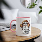 cute sloth coffee mug with pink handle and funny "I need coffee" design on wooden table