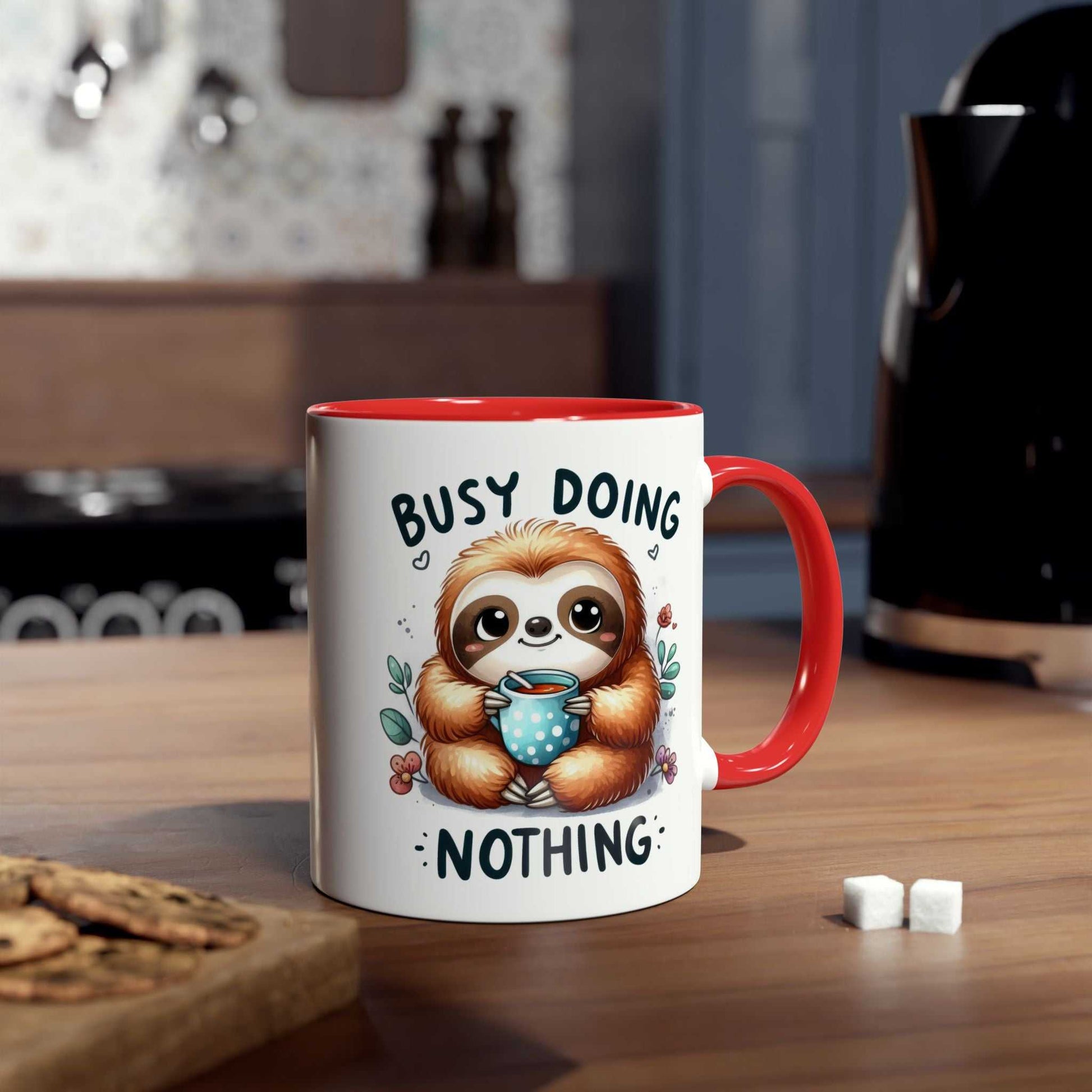 Cute sloth coffee mug with whimsical design, red interior, and "Busy Doing Nothing" text on a kitchen counter.