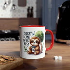 Cute sloth coffee mug with red handle and whimsical design on a kitchen countertop.