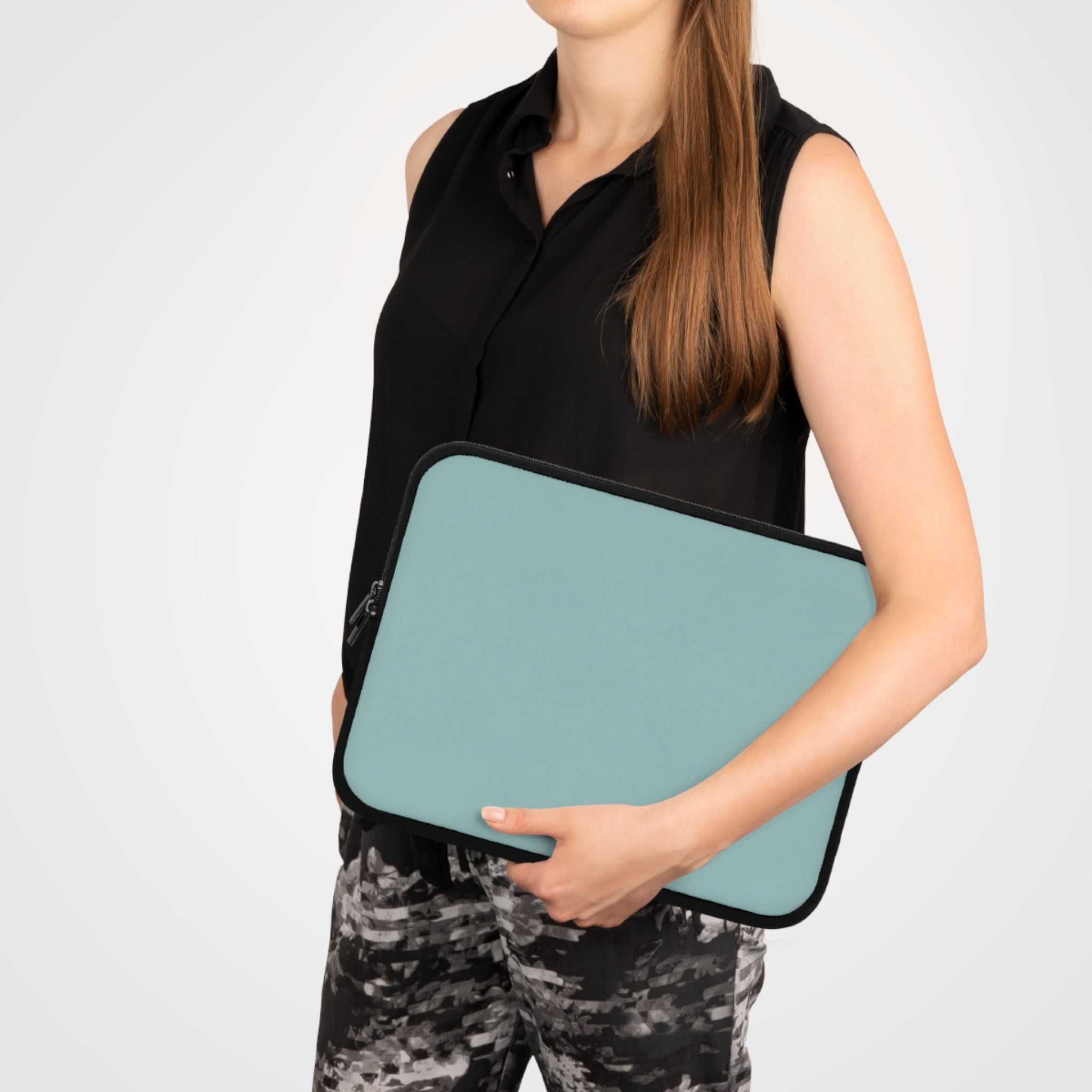 woman holding teal green neoprene laptop sleeve with black trim and zipper protection case